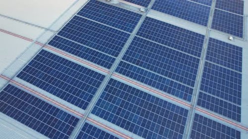Aerial cinematic view of a solar panel on mall roof top