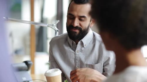 Happy multiethnic business team relaxing with coffee during office break