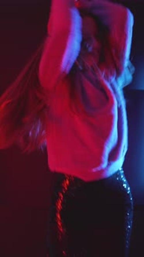 Woman Dancing in Club with Pink Sweater