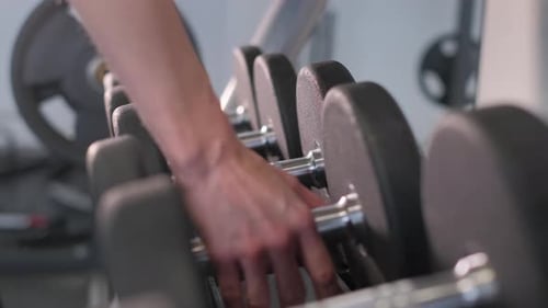 Closeup of a Woman's Hands in the Gym Lifting Dumbbells Sport Concept