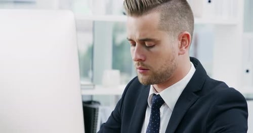 4k video footage of a young businessman working on a computer in an office