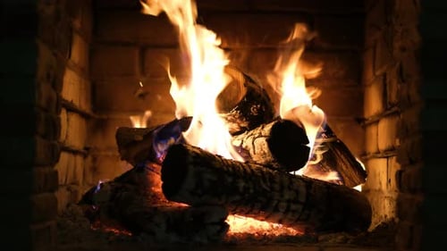 A fireplace with burning logs. Fire in the fireplace. A cozy place to rest.
