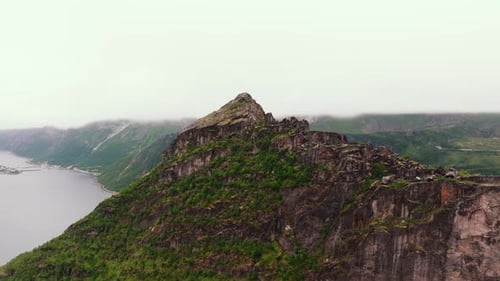 Aerial Exploration Mossy Mountain Wall Revealing Lofoten Islands' Rocky Coastline