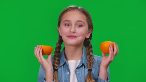 Closeup Funny Girl Licking Orange Smiling Looking at Camera Grimacing on Green Screen Portrait of
