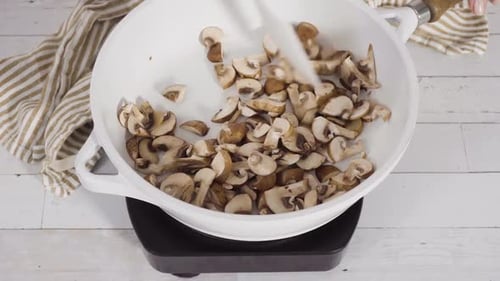 Sliced Mushrooms Cooking in a White Pan