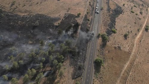 Passenger bus on fire and smoking on highway after accident, drone shot top view