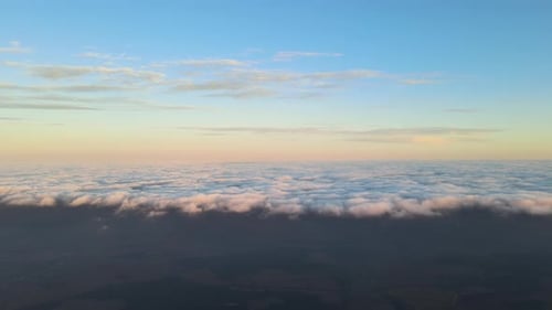High Altitude View of Bright Colorful Sunset Sky with Vivid Smooth Layer of Clouds Illuminated with