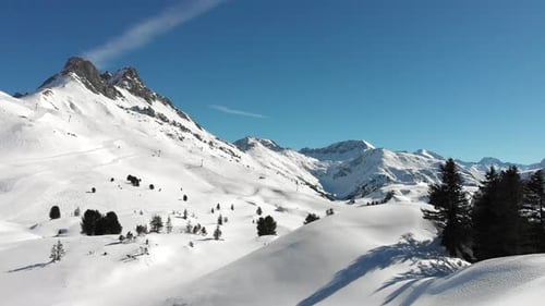 Vue aérienne de chaînes de montagnes enneigées et de quelques skieurs à Warth, une petite municipalité du Vorar