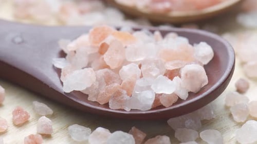 Closeup view of wooden spoons with Himalayan salt crystals