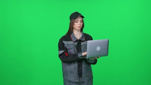 Digital Engineer Focused Woman Worker in a Uniform Technical Engineer Stands and Uses a Laptop on a
