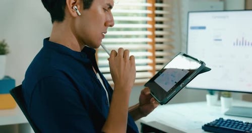 Close up positive young freelance Asia male use laptop and tablet remote work on desk.