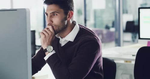 4k footage of a focussed young businessman working behind his computer screen in the office