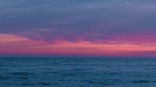 Pink Clouds on the Horizon Over the Ocean