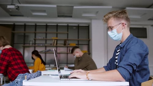Young Students with Face Masks at Desks at College or University, Coronavirus