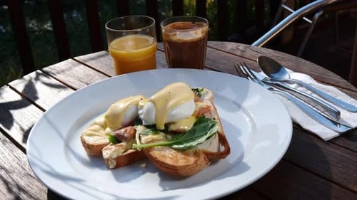 Delicious Eggs Benedict Breakfast with Juice and Coffee