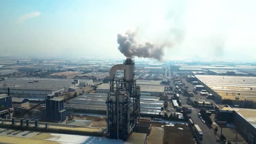 El humo espeso que sale de una chimenea industrial resalta la contaminación del aire y su impacto ambiental