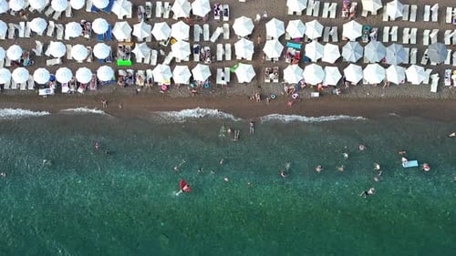 Static Aerial View of a Beach in the Adriatic Sea with Umbrellas and People Swimming