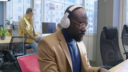 Man Working on Laptop in Modern Open Office