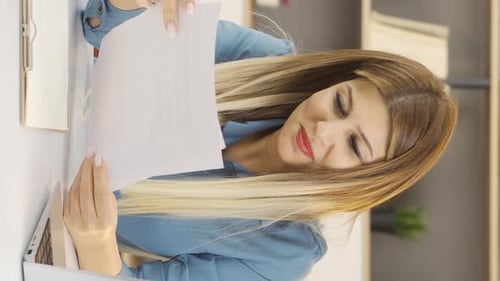 Businesswoman Examines Charts in Office