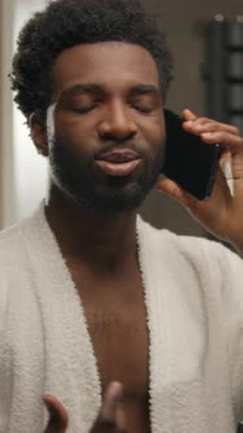Man in Robe Talking on Phone Indoors
