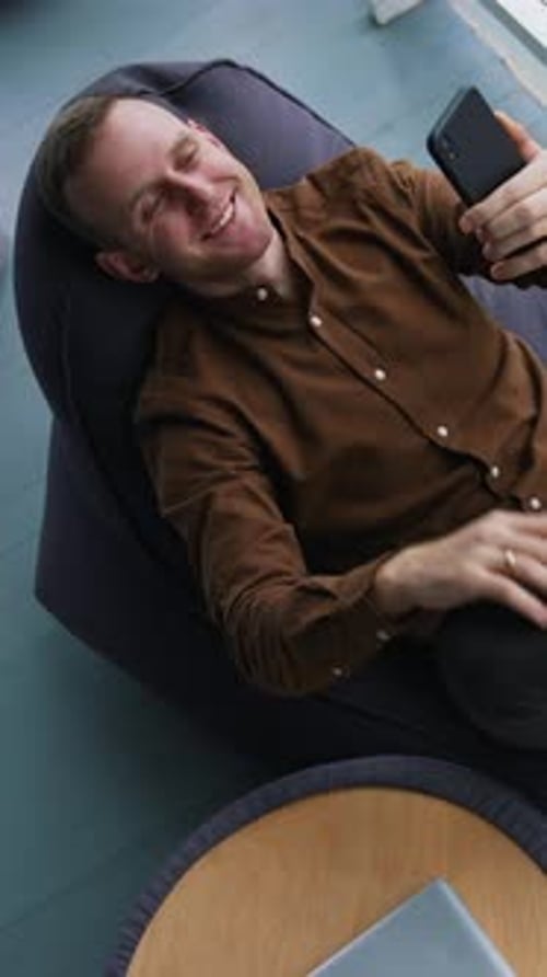 Man Video Chatting, Relaxing in Beanbag Chair