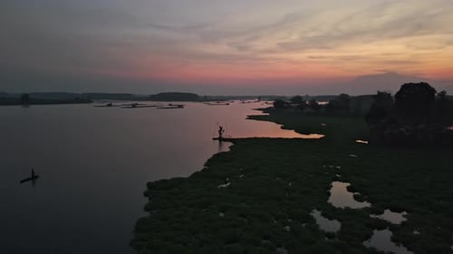 Ein Luftbild einer Dämmerungsszene über einem See mit Booten und üppiger grüner Landschaft