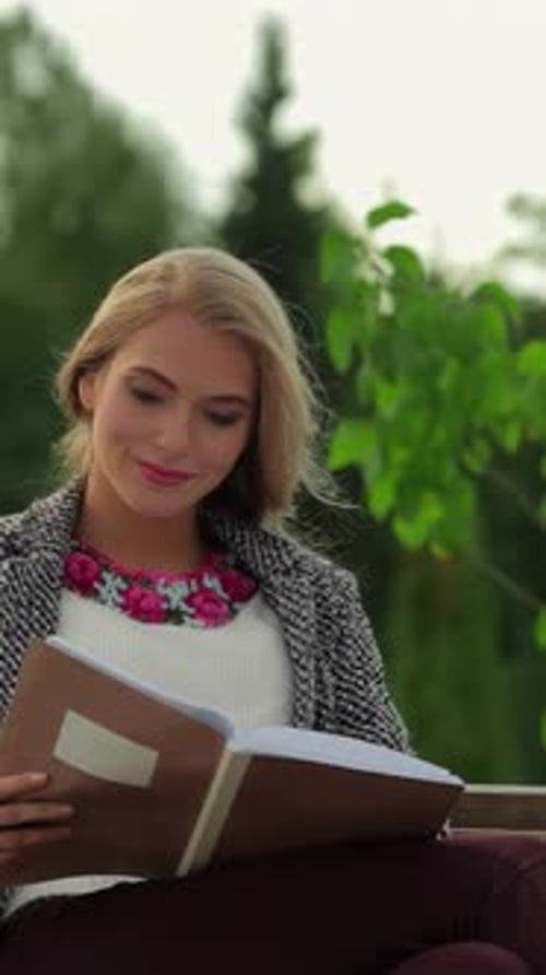 Charming Girl Student Immersed in Reading on a Sunlit Park Bench
