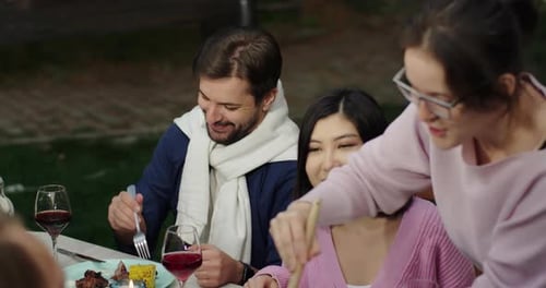 Friends Enjoying Outdoor Meal in the Evening