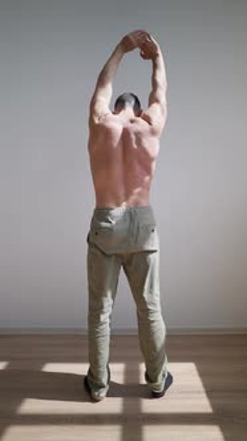 Man Stretching Back and Arms Indoors