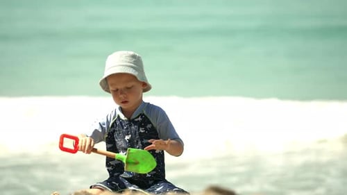 Child Playing in Sand by the Beach on a Sunny Day