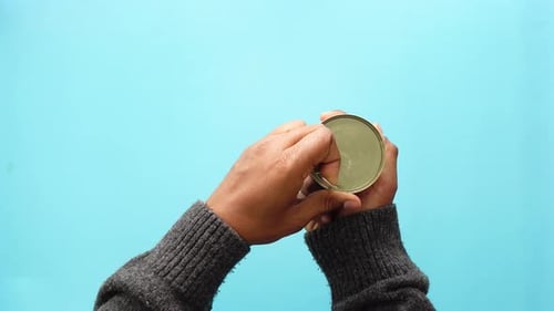 Hands opening can of corn with pull tab