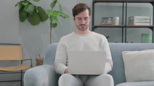 Man Using Laptop While Sitting on Couch