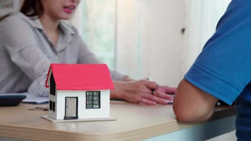 Real estate agent young asian woman talking with elderly couple and explaining mortgage.