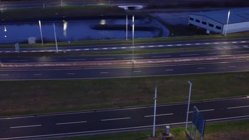 Aerial view modern illuminated quiet highway lanes road intersection traffic pan left following van