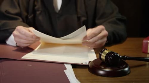 Judge closes up folder and hammers his gavel to end court case legal scene