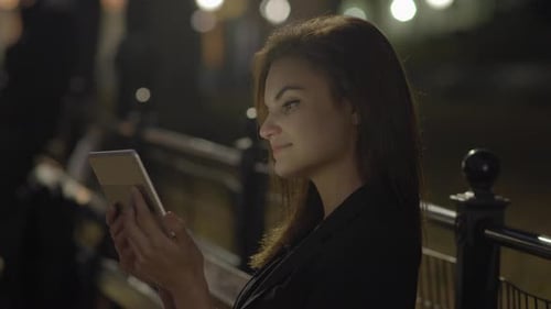 Young Woman Using Tablet Computer In The Park At Night