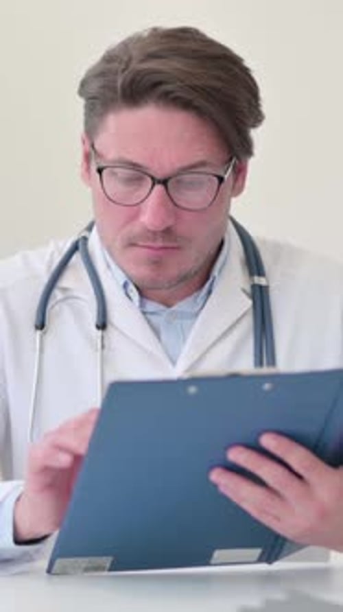 Médecin d'âge moyen lisant un dossier médical, Vidéo verticale
