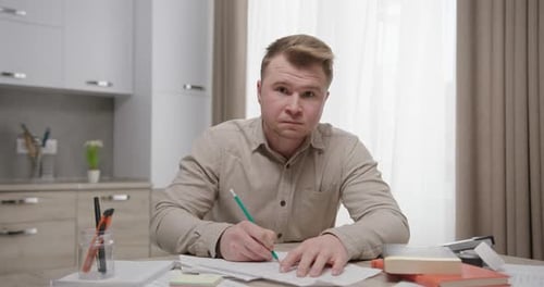 Angry Student Making Notes in Kitchen