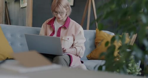 Woman Working on Laptop at Home on Couch