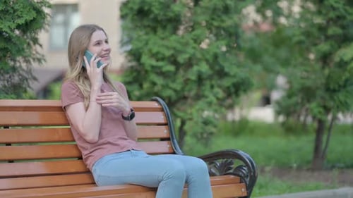 Smiling Woman Talking on Cell Phone in Park