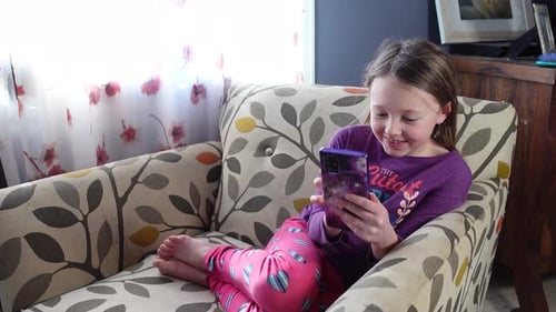 Girl Relaxing with Smartphone in Armchair