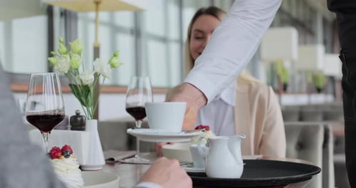 Close Up Waiter and Coffee on a Tray Walking to a Customer in or Restaurant Cafe Man and Woman