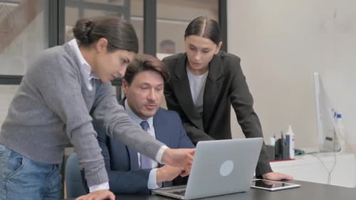 Focused Team Working Together at Office on Laptop