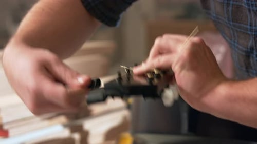 twisting the tuning knobs with a tool. at the end of the neck the guitar as the guitar needs new str