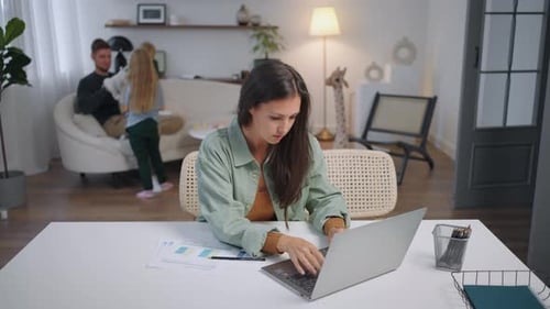 Una madre ocupada trabaja desde casa con una computadora portátil y trabaja desde la oficina
