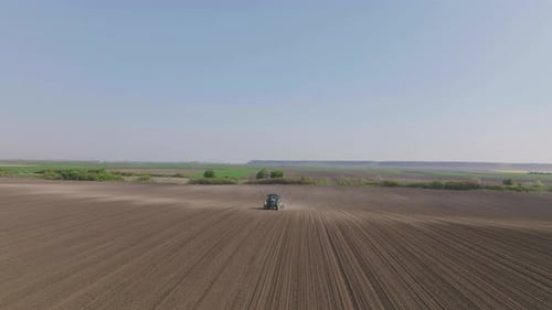 Tractor Plows Rural Farm Field, Aerial View