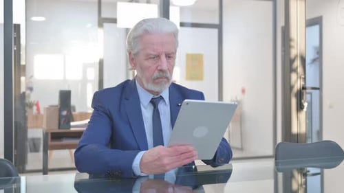 Senior Businessman Working on Tablet in Modern Office