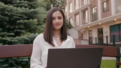 Woman Works On Laptop Outdoors in Park