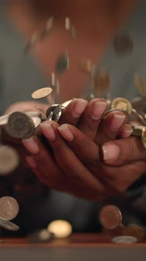 Hands Holding Coins with Falling Change Symbolizing Financial Transactions and Wealth Growth