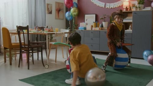 Two Happy Boys on Bouncing Balls Enjoying Birthday Celebration